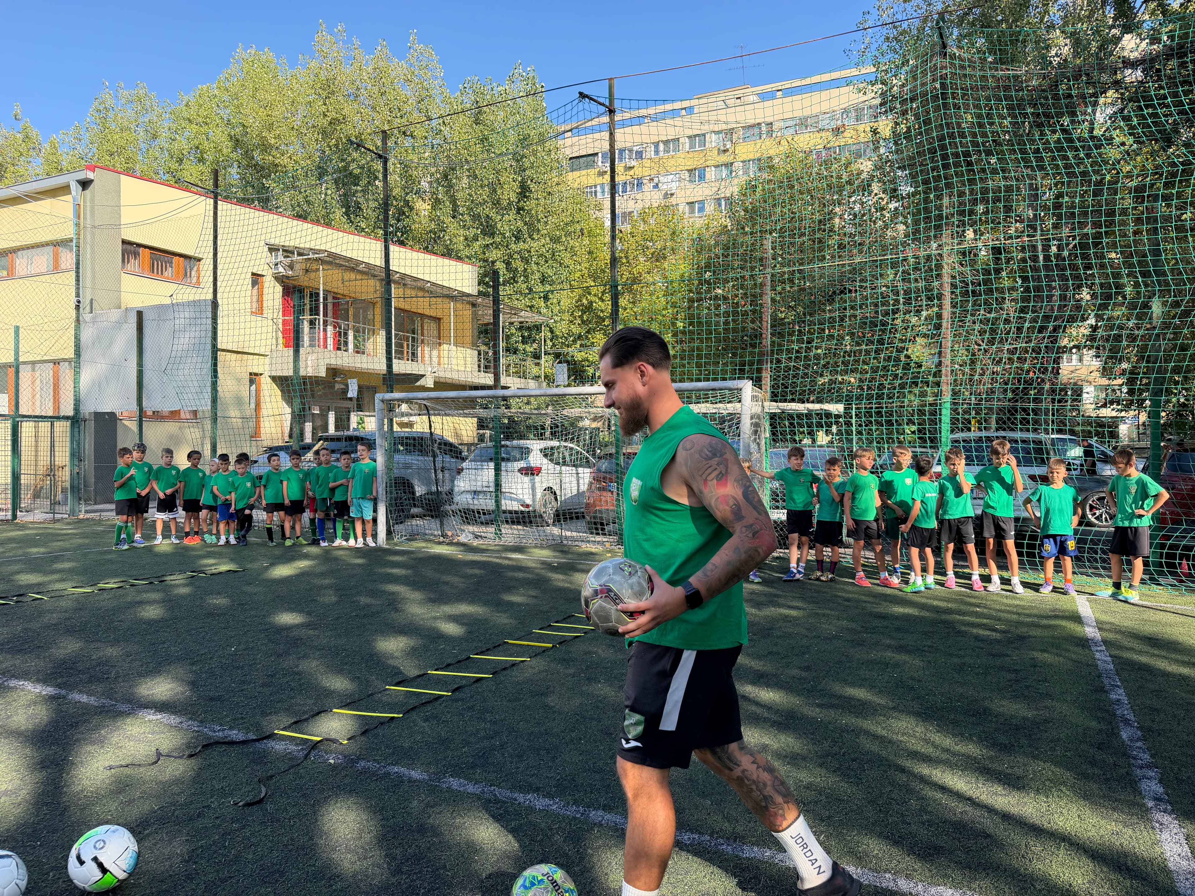 Grup de copii și antrenor, pe teren